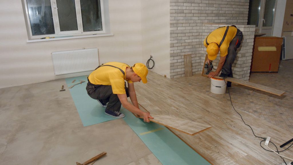 two workers installing wood flooring