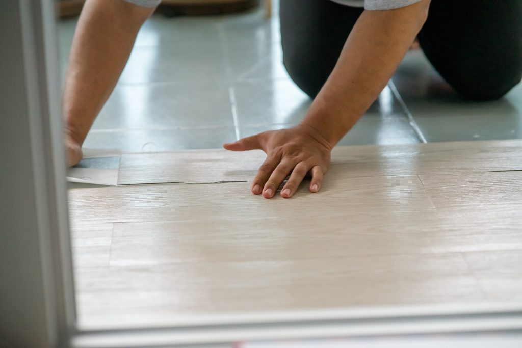 worker installing vinyl flooring
